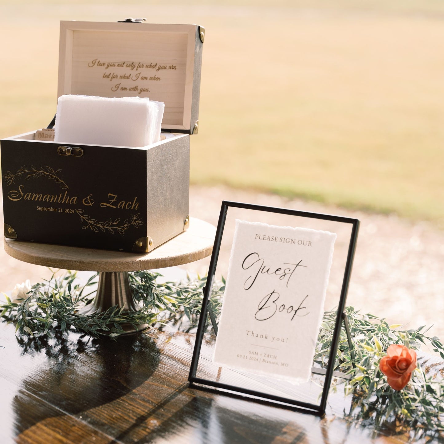 Black floating picture frame with Guest Book signage and a flared pedestal stand for rent - Picture Perfect Rentals