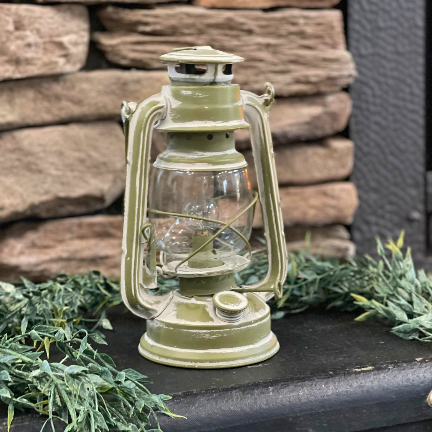 Green LED lantern turned off sitting on top of a black old antique suitcase - Picture Perfect Rentals