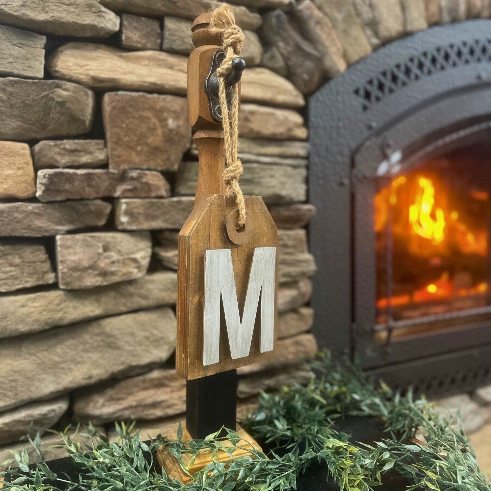 Unique wood sign holder holding a wood sign with a metallic letter "M" on it - Picture Perfect Rentals
