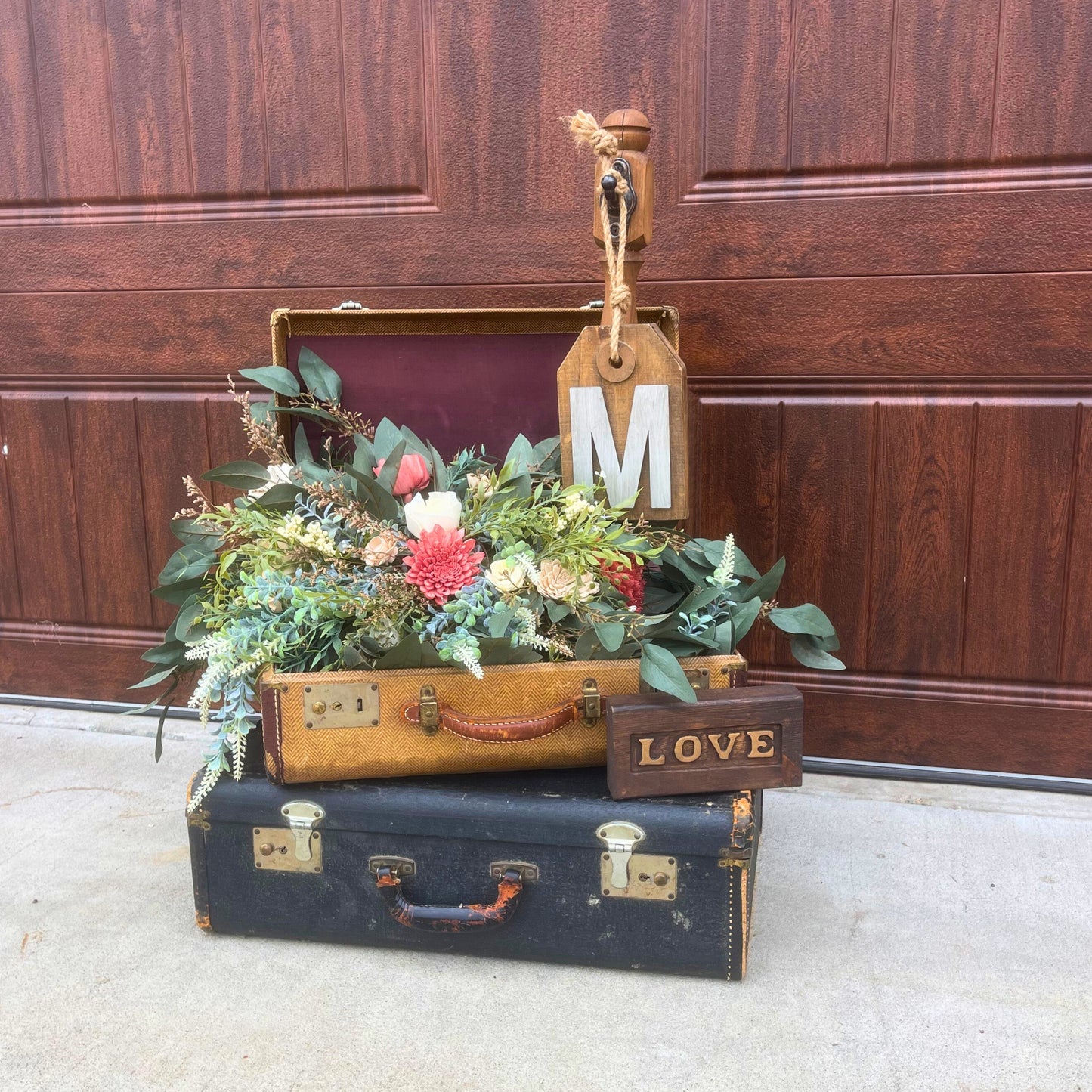 Vintage suitcases styled with floral bouquet and wooden signage for event decor rentals - Picture Perfect Rentals