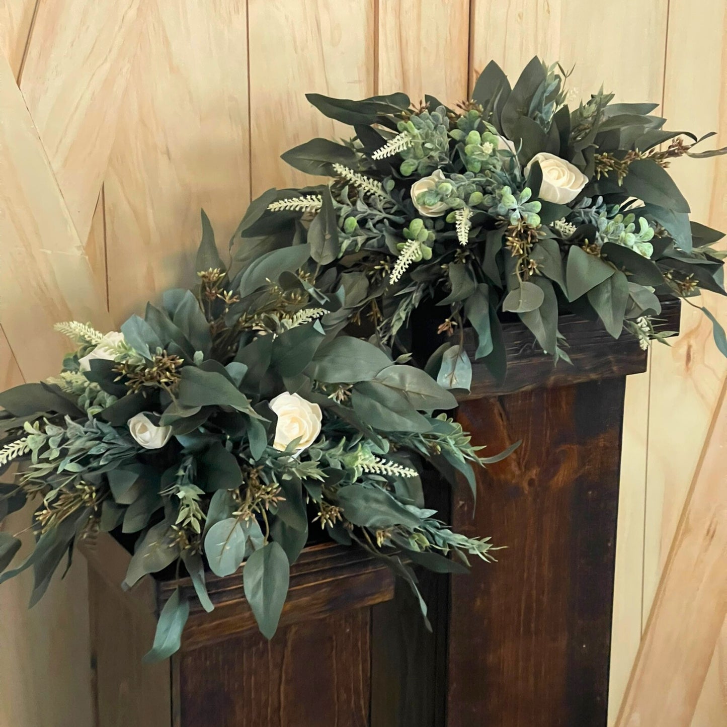 Seeded Eucalyptus and Cream Rose Centerpieces on Dark Stained Wood Pedestals for Rent - Picture Perfect Rentals Event Rentals in Wichita, KS