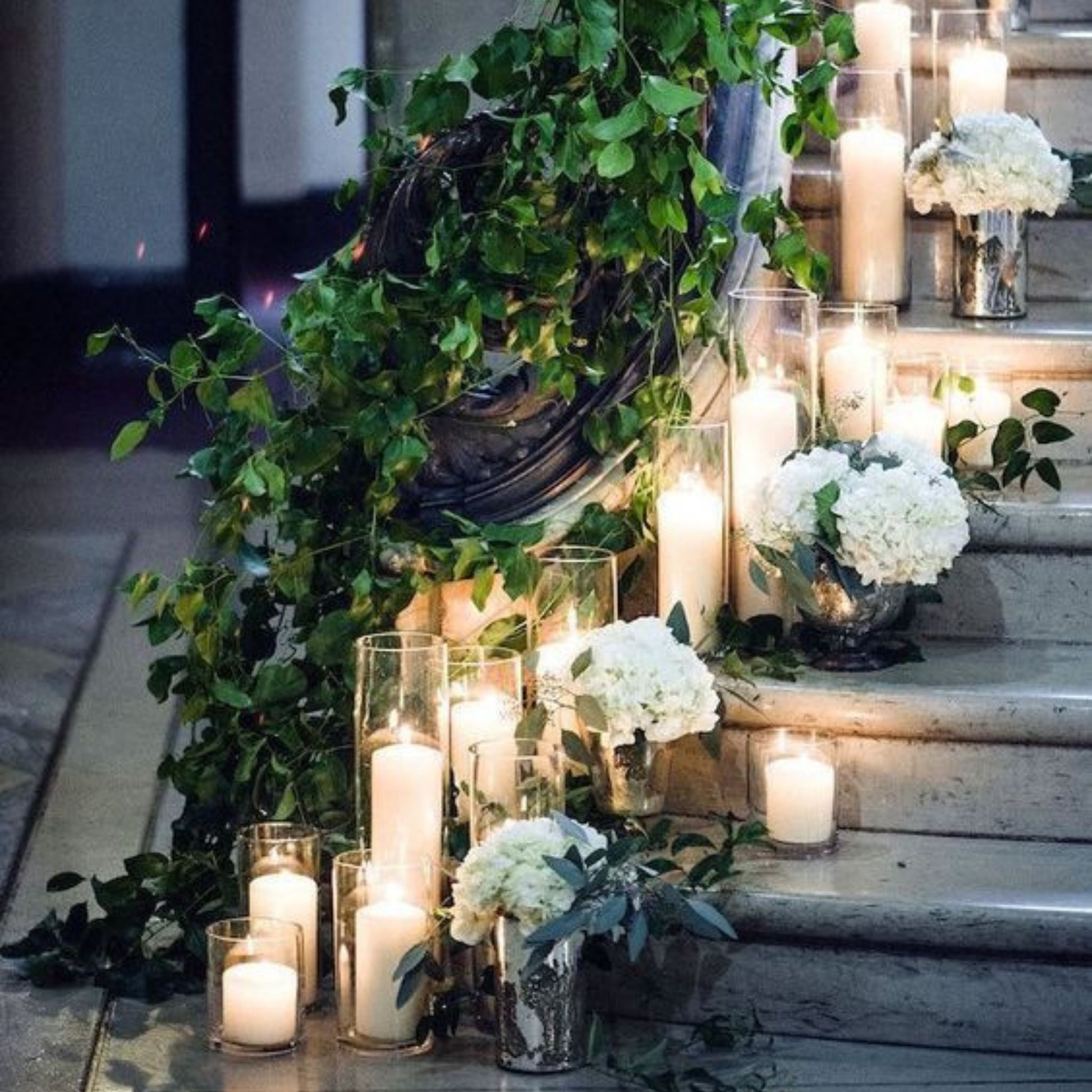 Clear glass cylinder vases with candles leading up a staircase - Picture Perfect Rentals